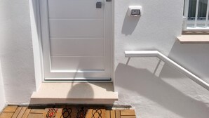 A white door with a small window above it, a wall-mounted light fixture, and a small electrical outlet. - Piccolo Nida 18 in Cattolica (Cattolica)