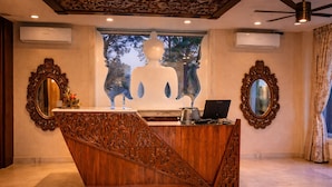 A reception desk with a Buddha statue, ornate mirrors, and an air conditioning unit. - Hotel Saheb's Castle - Best Mountain View & Jacuzzi Suites, McLeodganj (Dharamshala)