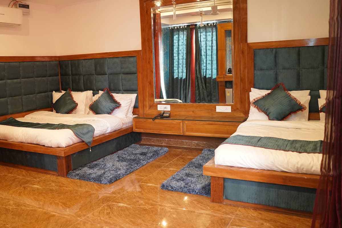 Une chambre d’hôtel avec deux lits, un grand miroir et une tête de lit en bois.