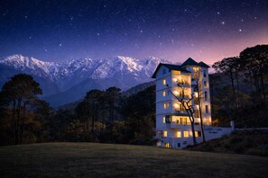 Un hôtel à plusieurs étages, doté de balcons et d’une enseigne indiquant qu’il s’agit du « Château de SAHEB dans les Alpes ».