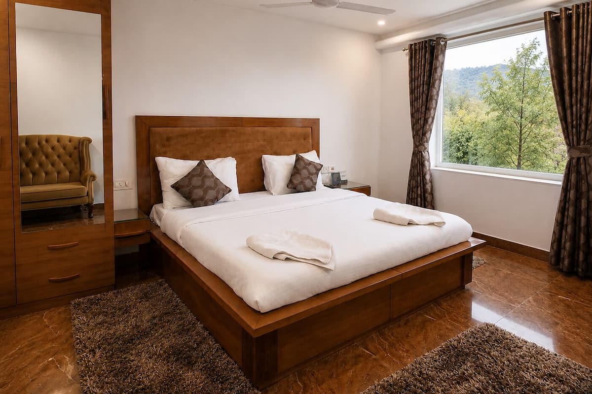 Une chambre à coucher avec un lit en bois, une table de chevet, un miroir, un canapé et une fenêtre avec des rideaux.