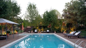 A rectangular swimming pool with a tiled deck surrounding it, equipped with lounge chairs and a covered seating area. - Luxury villa on a private estate in Toledo w/pool and views of Sierra de Gredos. (mejorada)