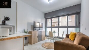 A modern apartment with a kitchen, dining area, and living room.