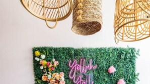 A wall with a green textured backdrop and a floral arrangement with the text "Yallah Yallah" in pink. - Comfort Suite | Near Mercer University & Downtown (Macon)