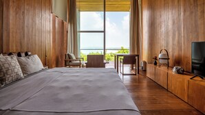 A bedroom with a large bed, a TV, a small table, and a view of the outdoors. - Villa Vista by The Serendipity Collection (Mirissa)