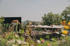 Enjoy al fresco dining under lush greenery and shaded tables.