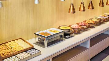 A buffet with various food items, a coffee station, and a self-service hot food station.