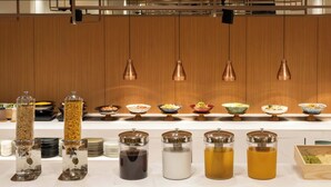 Una barra de buffet con distintos alimentos y bebidas.