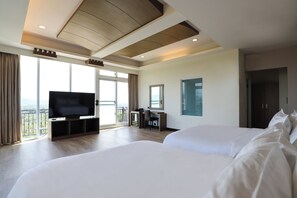 A hotel room with two large beds, a desk with a chair, a television, and a large window with a view. - The South - Dawn (Hengchun)