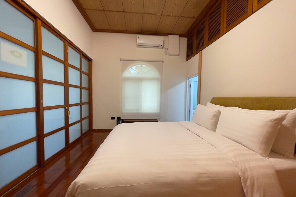 A room with a bed, a sliding door, and a window with a view.
