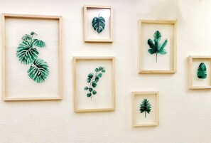 A wall with six framed botanical prints of different leaves.