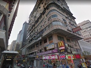 Een meerhoog gebouw met diverse gevelreclames, waaronder een McDonald's en een Samsung Canon winkel.
