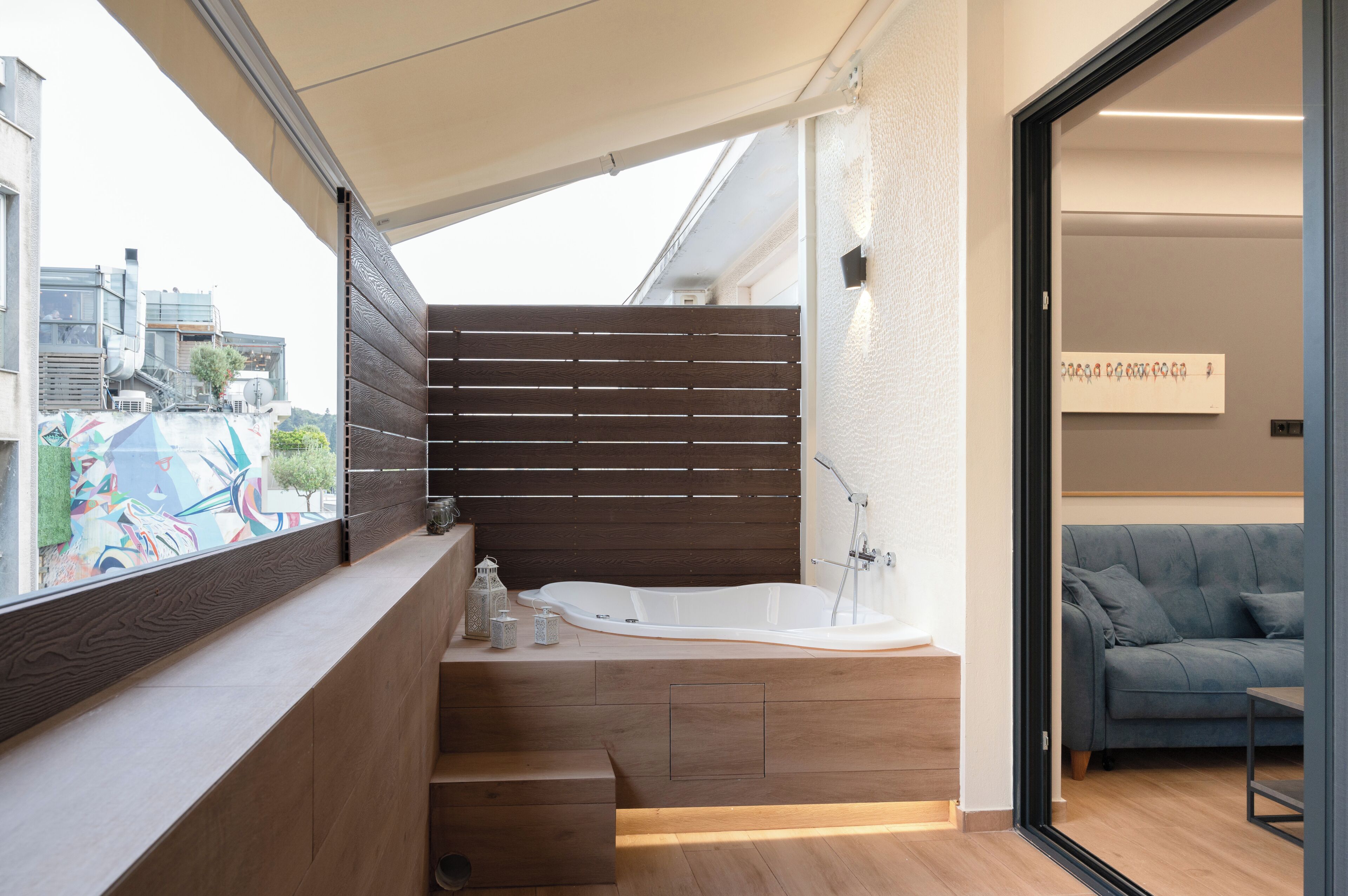 Un baño moderno con una bañera independiente, paneles de madera y vistas a la ciudad.