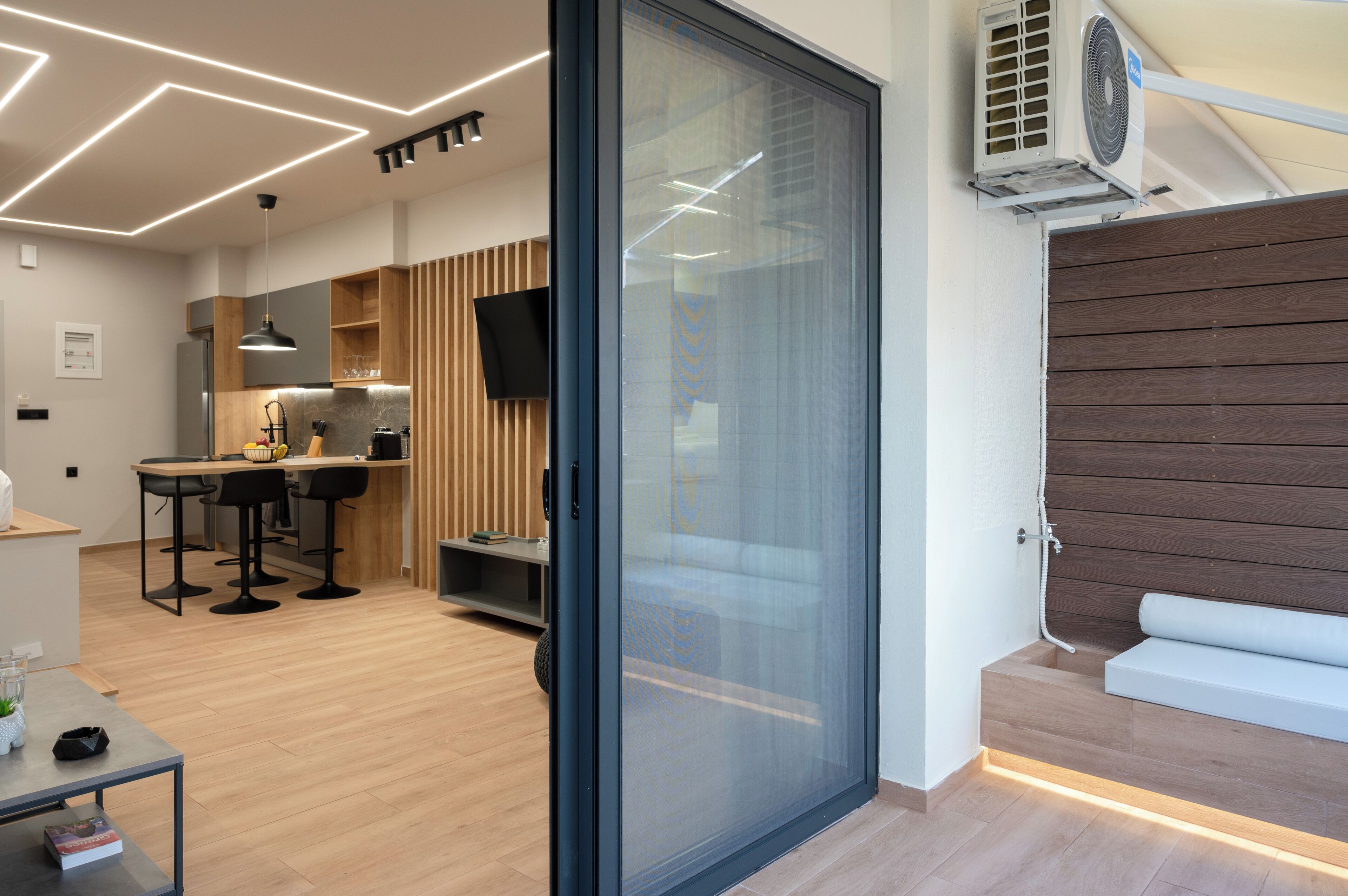 A modern kitchen with a built-in stove, wooden accents, and a large window.