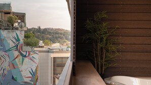 Een balkon met uitzicht op een stadslandschap, een houten wand en een jacuzzi.