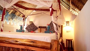 Ein Zimmer mit einem Bett, einem Baldachin, Kissen und einem Nachttisch.
