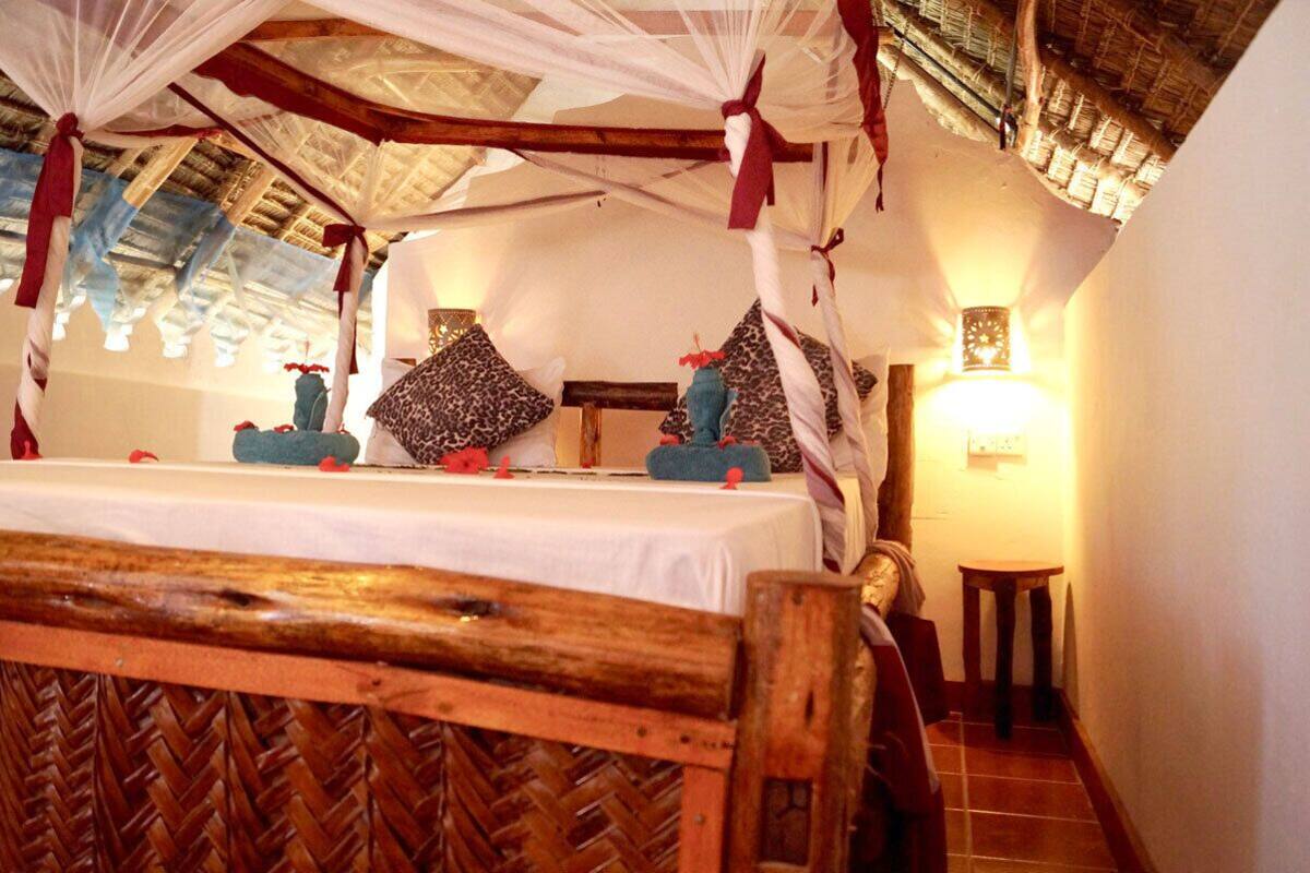 Ein Zimmer mit einem Bett, einem Baldachin, Kissen und einem Nachttisch.