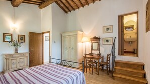 A bedroom with a bed, wooden wardrobe, desk, chair, and a staircase. - Ocabianca Holiday Home with Private Terrace, Wi-Fi and Air Conditioning (Casole d'Elsa)