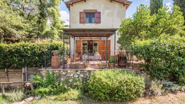 A two-story house with a stone foundation, wooden shutters, and a covered porch with outdoor furniture. - Ocabianca Holiday Home with Private Terrace, Wi-Fi and Air Conditioning (Casole d'Elsa)