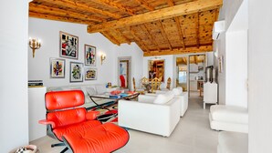 A modern living room with a red chair, white sofas, and a wooden ceiling. - Holiday Home "Villa Maryna" with Sea View, Private Terrace, Pool and Wi-Fi (Olbia)