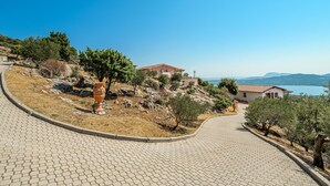 A paved pathway leading to a hillside property with a house and a view of the sea. - Holiday Home "Villa Maryna" with Sea View, Private Terrace, Pool and Wi-Fi (Olbia)