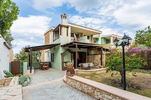 A two-story house with a patio, outdoor furniture, and a small garden. - Villa 'Alice' with Private Terrace, Wi-Fi and Air Conditioning (Villasimius)