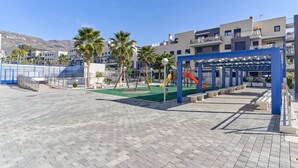 Leikkikentällä on keinut ja liukumäet, katettu oleskelualue sekä päällystetty kävelyreitti.