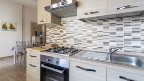A modern kitchen with a gas stove, oven, and stainless steel sink. - Holiday Apartment "Samuel Beach Con Veranda" with Private Terrace & Wi-Fi (Cava D'Aliga)
