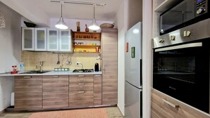 A modern kitchen with wooden cabinets, a built-in oven, and a gas stove. - Apartment 'Casa Alamar' with Private Garden, Wi-Fi and Air Conditioning (Alcamo)