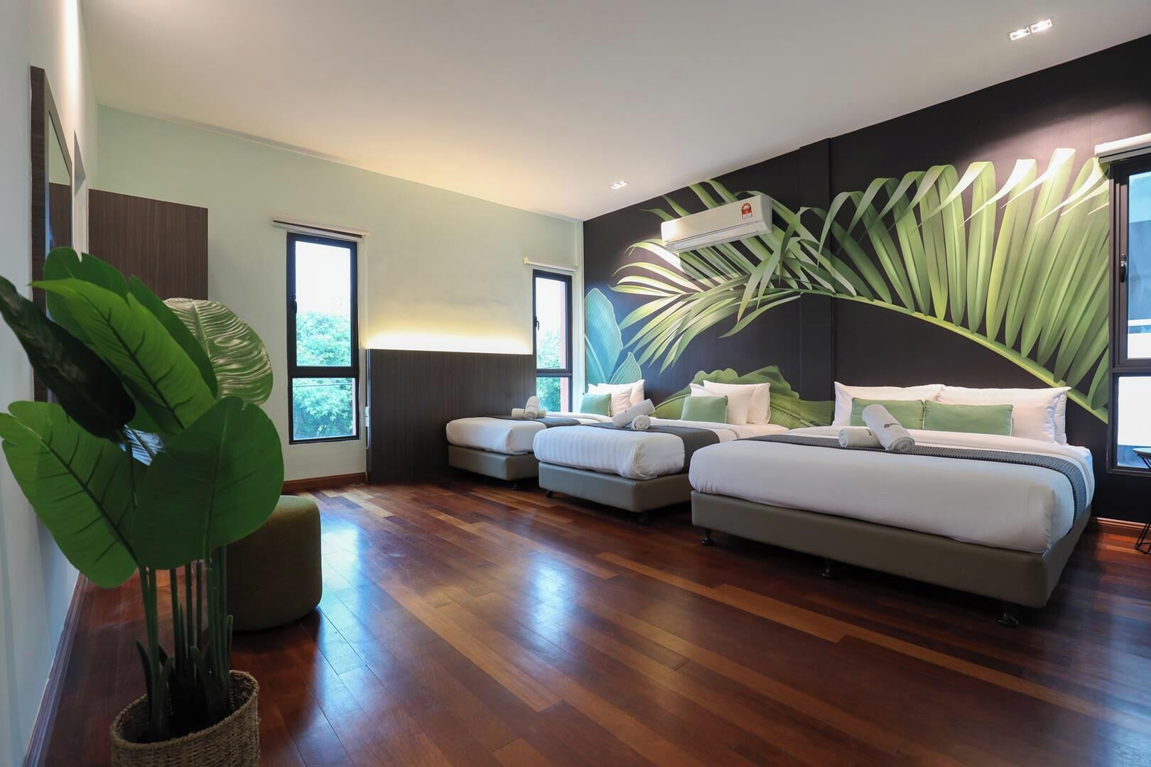 Une chambre moderne avec deux lits, une grande fenêtre et une fresque murale.
