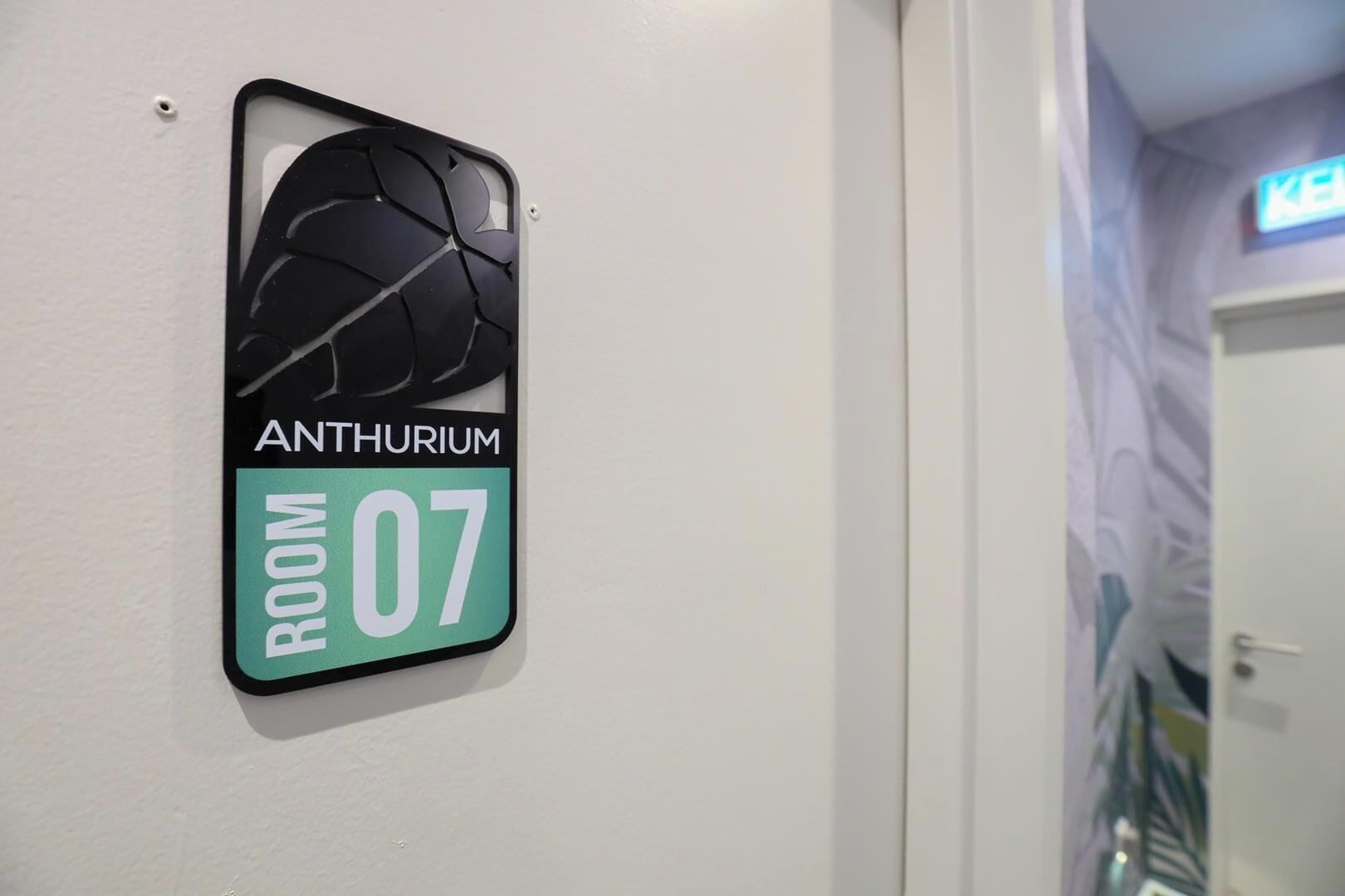 Eine an der Wand befestigte Schilderung für 'ANTHURIUM ROOM 07' mit einem rissigen Glasmuster.