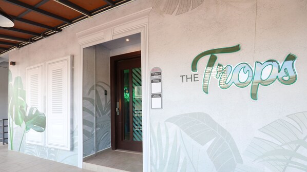 A hotel entrance with a sign reading "THE Tuops" and a contact number for walk-in guests. - Trevor Hotel by I Housing (Malacca City)