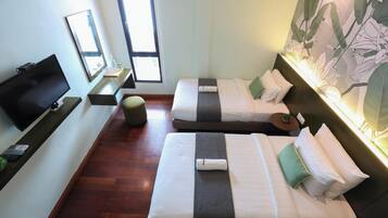 Habitación de hotel con dos camas, televisión, una mesita y una ventana.