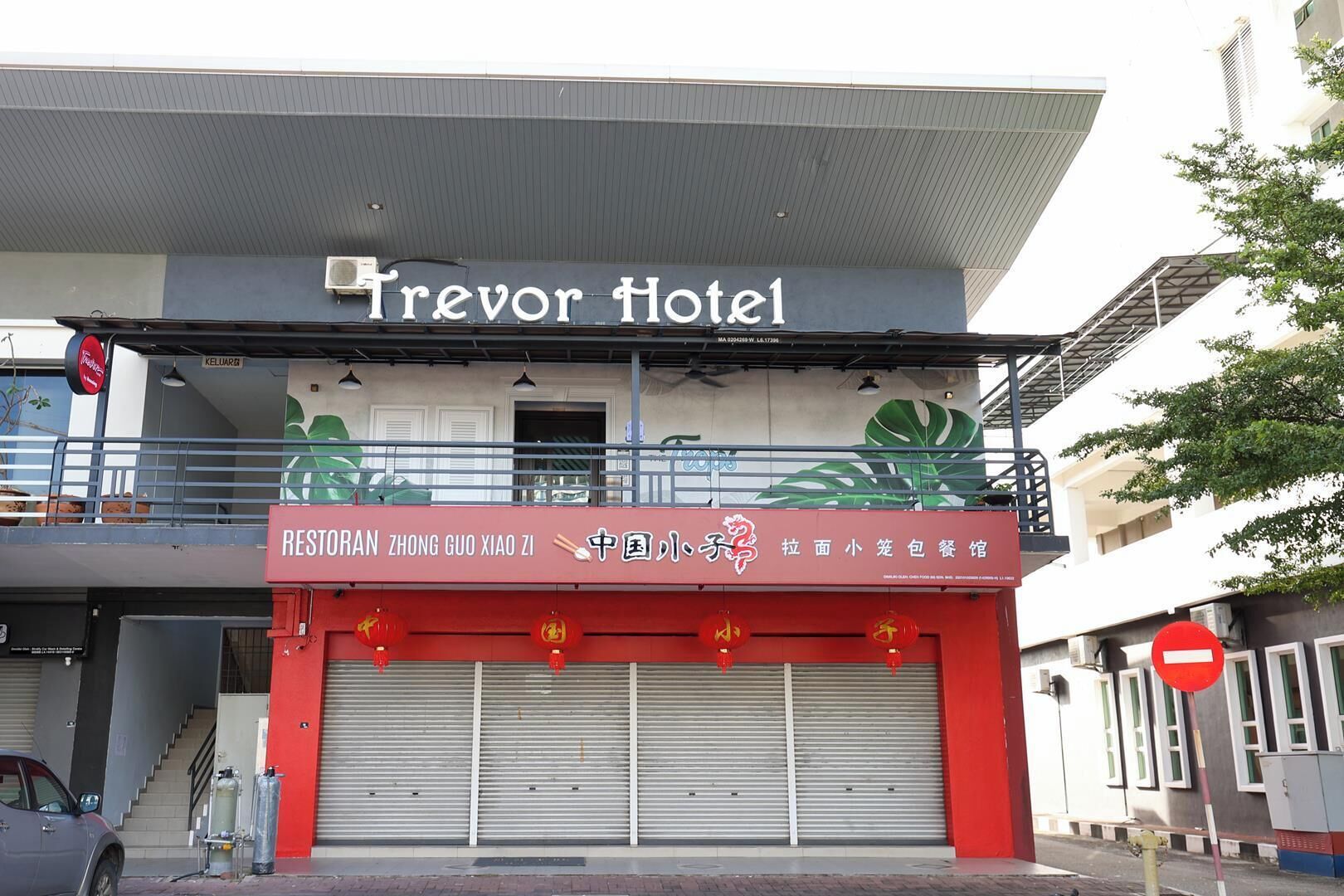A hotel with a sign reading 'Trevor Hotel' and a restaurant named 'Restoran Zhong Guo Xia Zi' below it.