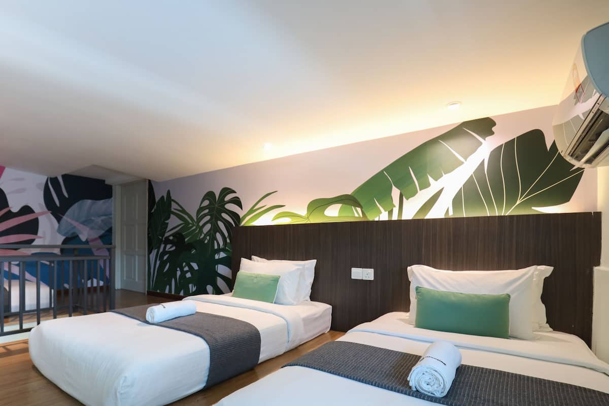 A hotel room with two beds, a balcony, and a large wall mural.