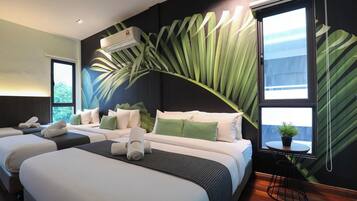 Habitación de hotel con dos camas, un ventanal grande y un aire acondicionado instalado en la pared.
