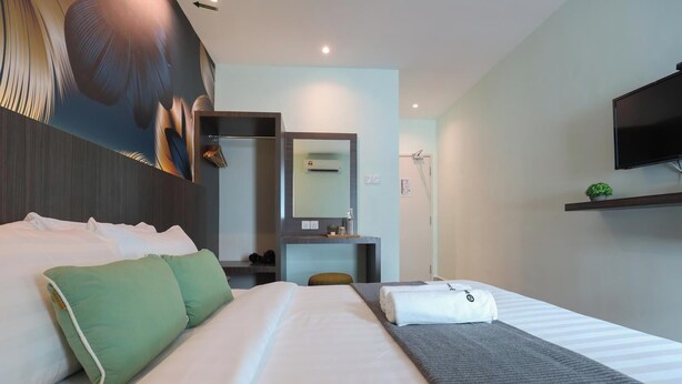 A hotel room with a bed, a desk, a chair, a television, and a mirror. - Trevor Hotel by I Housing (Malacca City)