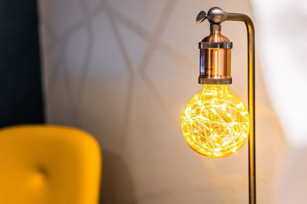A light fixture with a spherical bulb and a metallic base.