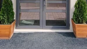 A modern building entrance with a glass door and a number '39' on the wall. - HOTEL39 (Plovdiv)