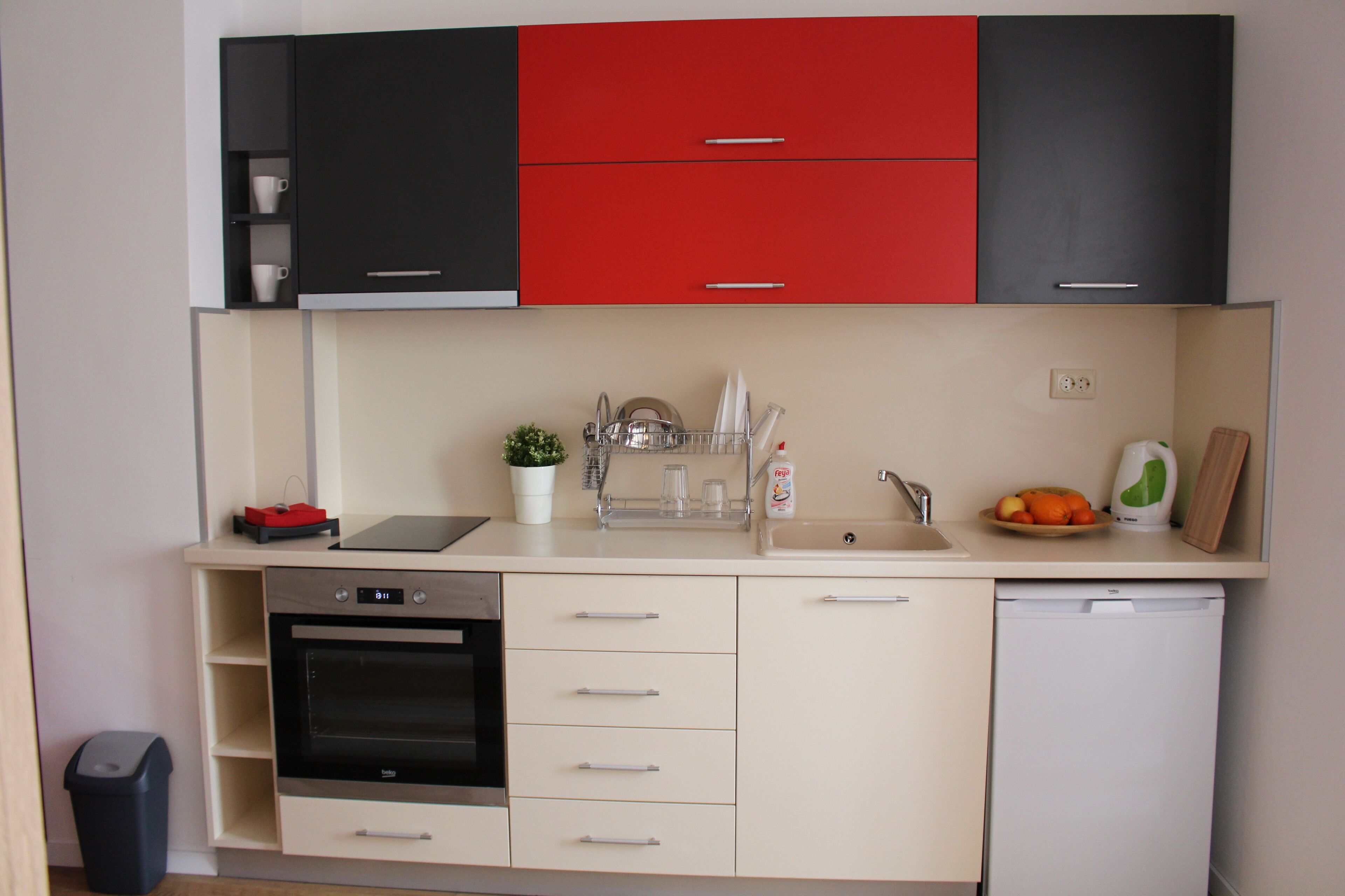 A compact kitchen with a dishwasher, oven, and a small sink.