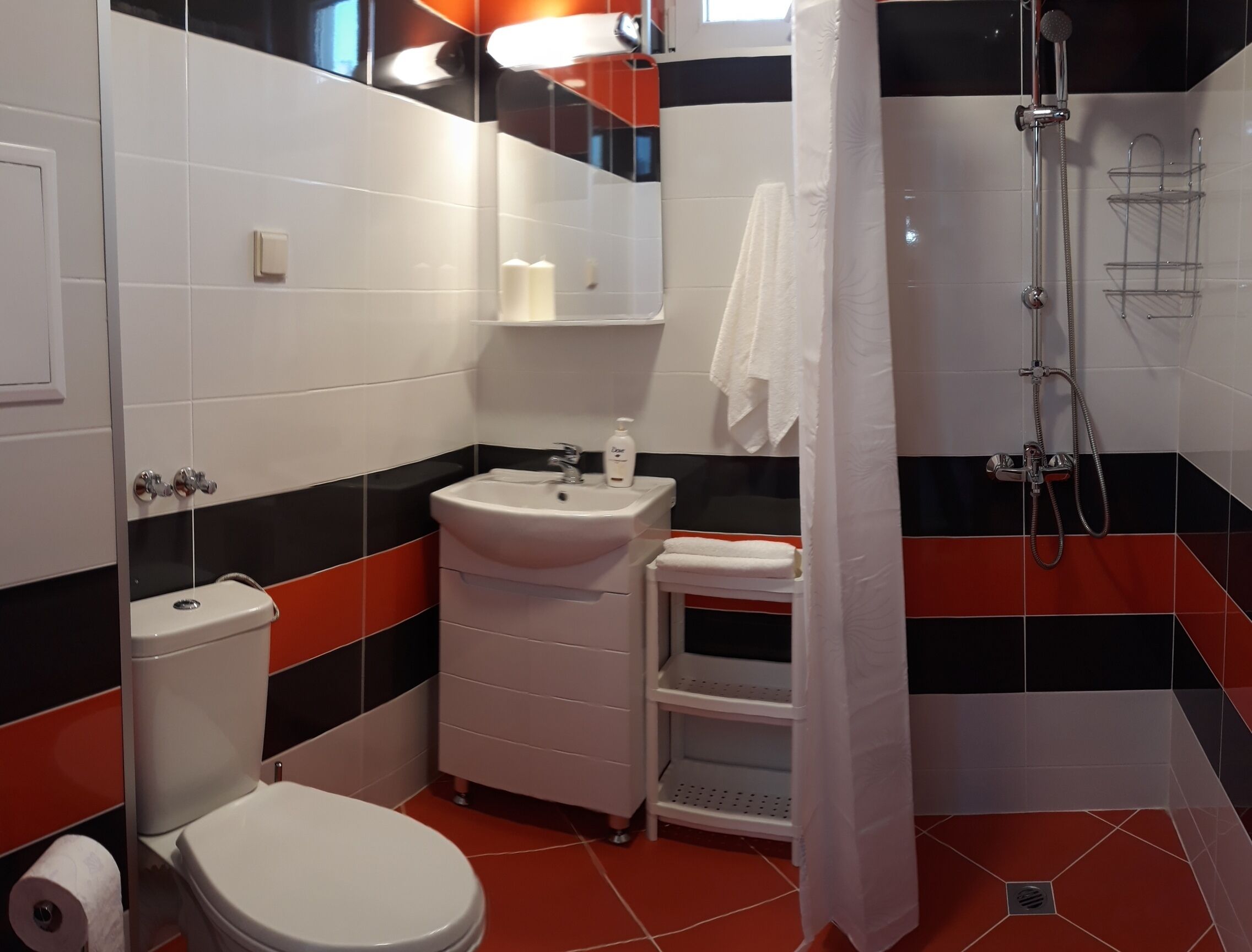 A bathroom with a toilet, sink, and shower.