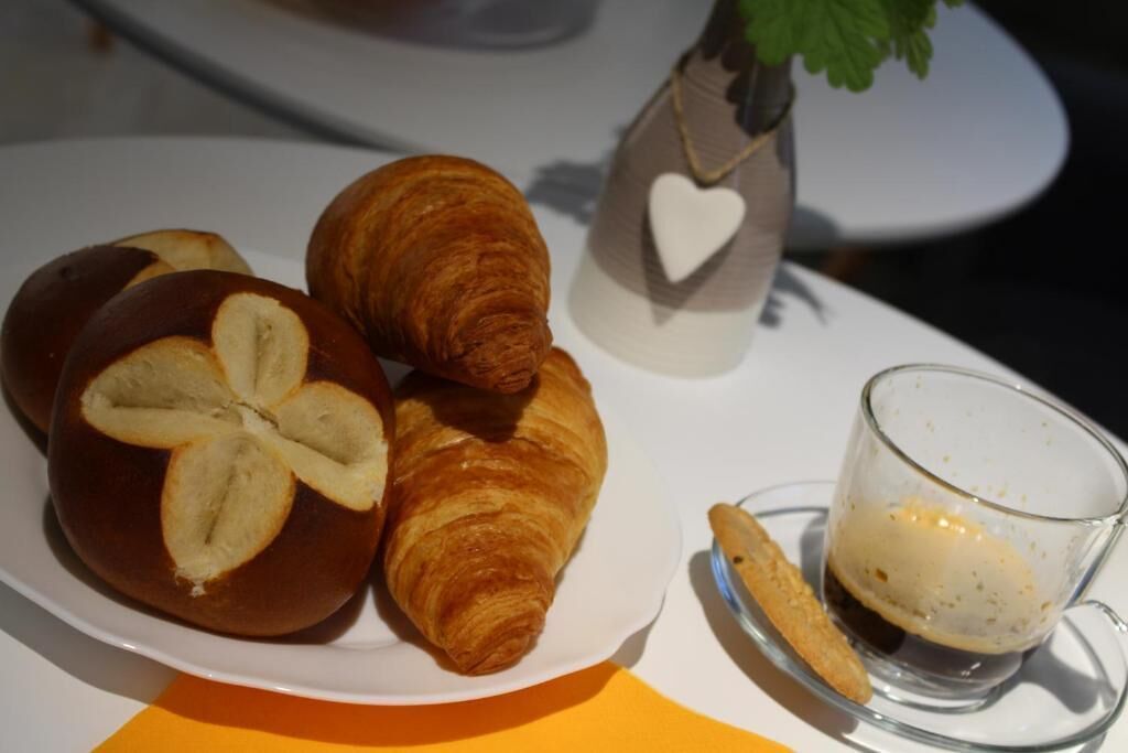 A plate with croissants and a glass of coffee.