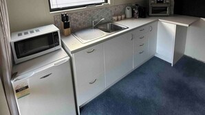 A compact kitchenette with a microwave, sink, and small refrigerator. - Country cottage close to airport (pet friendly)  (West Melton)
