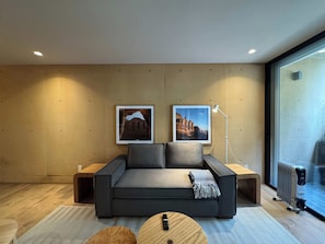 A modern living room with a sofa, two framed pictures, a floor lamp, and a radiator. - w* | Alluring 2BR with Balcony in Condesa (Ciudad de México)