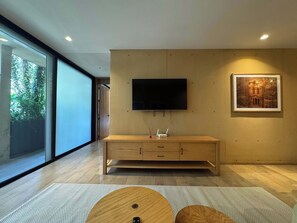 A modern living room with a wooden cabinet, a mounted TV, and a framed picture on the wall. - w* | Alluring 2BR with Balcony in Condesa (Ciudad de México)