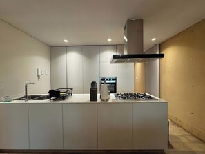 A modern kitchen with a central island, built-in appliances, and recessed lighting. - w* | Alluring 2BR with Balcony in Condesa (Ciudad de México)