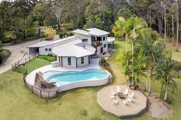 The expansive home with an incredible pool and fire pit area.