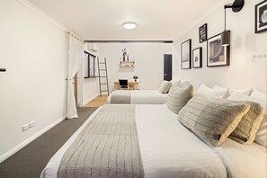 A hotel room with a large bed, a desk with a chair, a ladder, and a door. - The Noosa Ranch - Where Nature meets Luxury (Tinbeerwah)