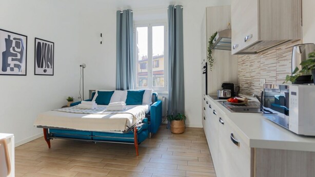 A modern bedroom with a bed, a bedside table, and a window with curtains. - The Best Rent - Contemporary two bedroom flat in Porta Romana (Milano)