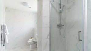 A modern bathroom with a glass-enclosed shower, a toilet, and a towel rack. - Contemporary 1 Bedroom Liverpool Apartment (Liverpool)